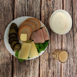 Zdjęcie przedstawia Dietę podstawową: Chleb mieszany pszenno-żytni Masło extra Schab Kruchy z Liszek Ser mozzarella Og&oacute;rek kiszony Sałata zielona Kawa zbożowa z mlekiem Makaron na mleku